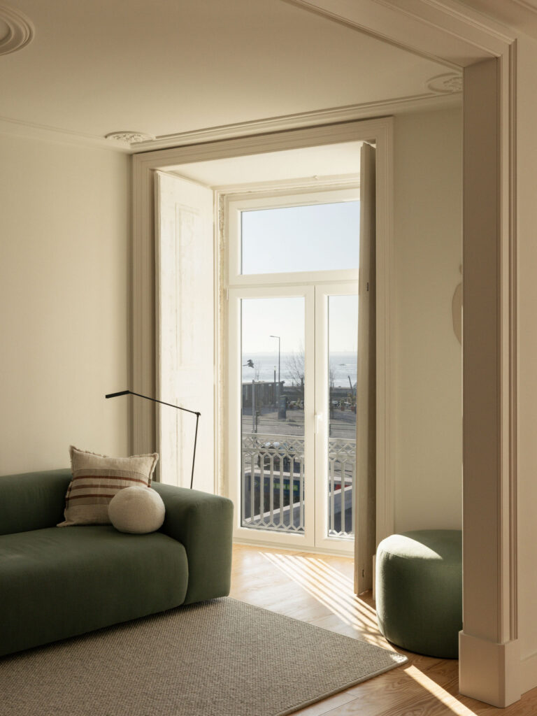 Living room with green sofa and open balcony door