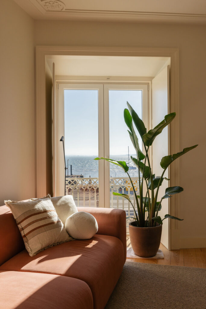 Living room with terracotta sofa and river view – LIOZ Lisboa