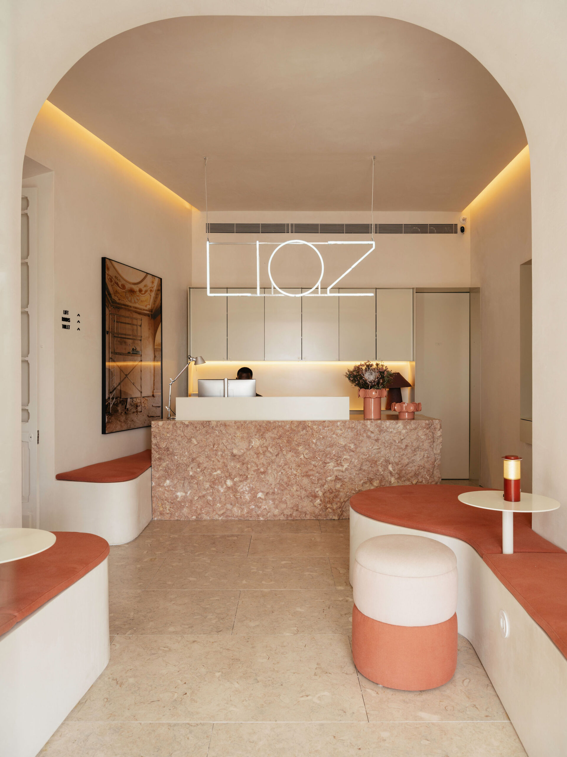 The reception, under a vaulted ceiling, with a pink terrazzo counter